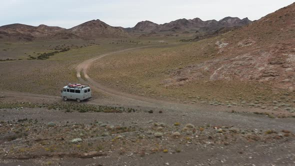 Offroad Vehicle Goes on a Dirt Road Among the Mountains