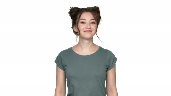 Portrait of Lovely Woman with Double Buns Hairstyle Smiling and Expressing Agreement with Nodding
