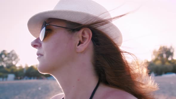 Close Up of a Freedom Woman on the Beach at Sunset Hair Blowing in the Wind Side View Summer Day