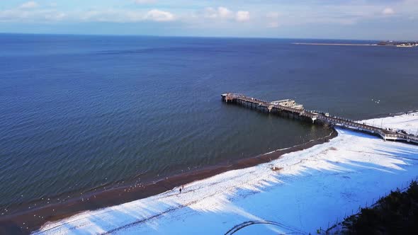 Gdansk Brzezno pier in winter, aerial shot. Flying backwards, away from the pier. Sunny winter day.