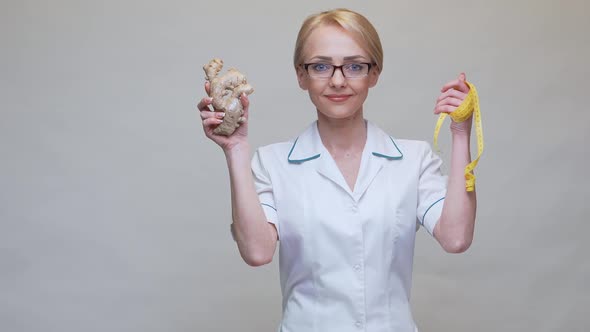 Nutritionist Doctor Healthy Lifestyle Concept - Holding Ginger Root and Measuring Tape