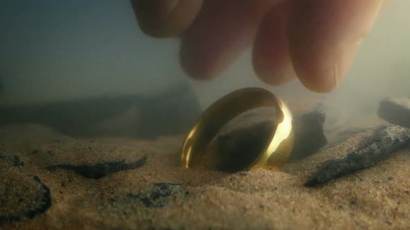 Someone Picks Up Gold Ring From River Bed