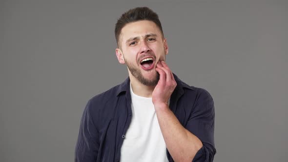 Portrait of Sensitive Guy in Casual Clothing Suffering From Awful Toothache and Touching Cheek with