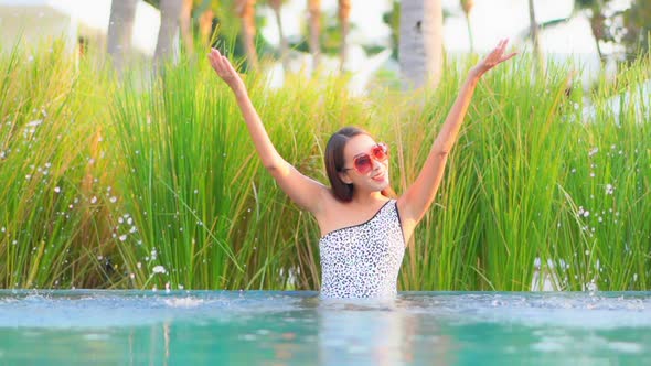 Young asian woman enjoy around outdoor swimming pool for leisure