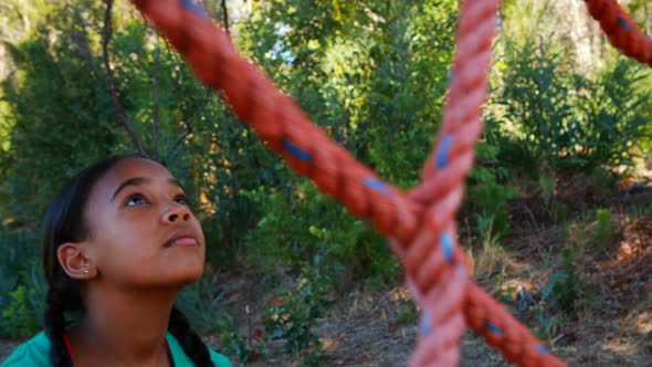 Determined girl climbing a net during obstacle course