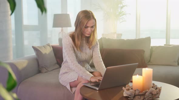 Woman Typing on Laptop and Using Smartphone at Home