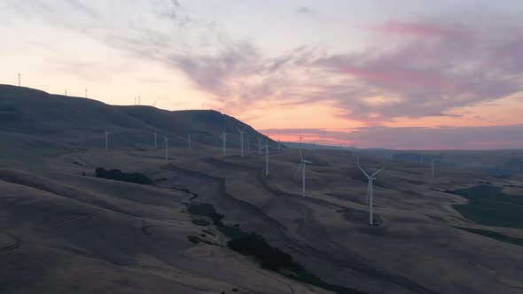 Beautiful Aerial Landscape View of Wind Turbines on a Windy Hill during a colorful sunrise. Taken in