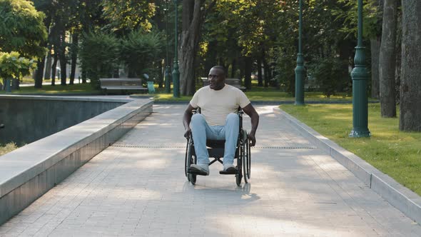 African American Man with Disability Moves Use Both of Hands in Active Wheelchair