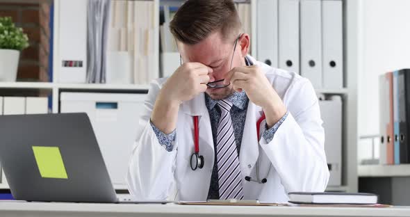 Tired Doctor Sitting at Computer and Taking Off His Glasses  Movie