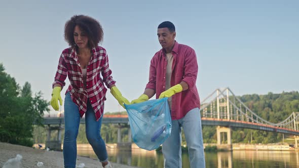 African American Volunteers Remove Plastic Bottles on Beach