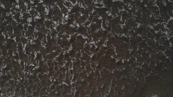 Top Down View Of Foamy Sea Waves Washing On The Shore At The Beach Near Brouwersdam, Netherlands - a