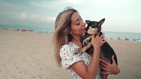 Small Dog Named Artur with Owner, Young Woman, Playing on the Beach