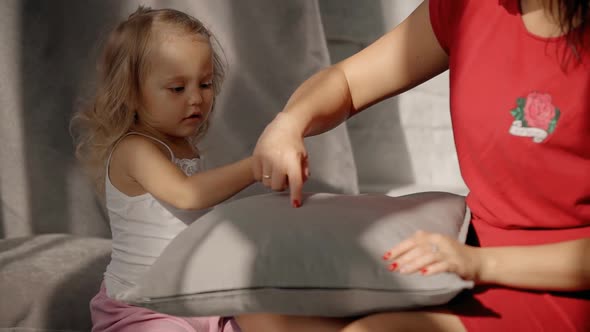 Beautiful Mother in Red Clothes Is Teaching and Showing Something