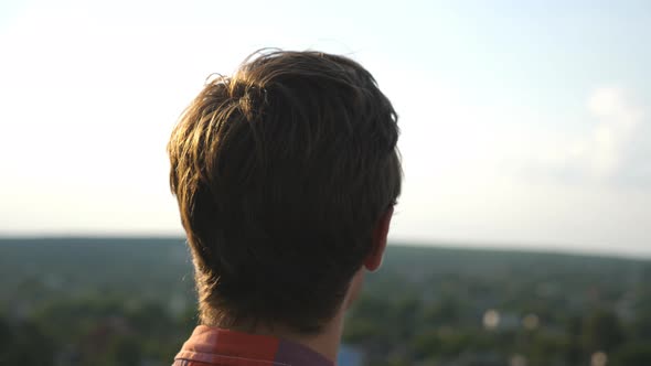 Dolly Shot of Young Man in Sunglasses Watching Panorama of the City From Rooftop of High-rise