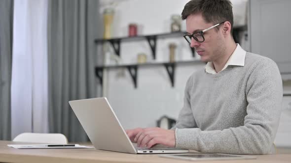 Young Man Working on Laptop at Home