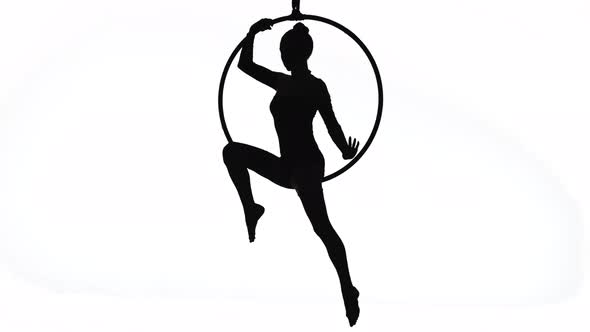 The Black Silhouette of an Aerial Gymnast Performing Acrobatic Tricks and Spinning in the Air on the
