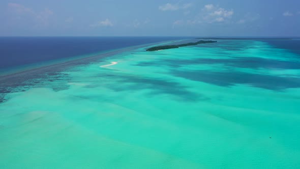 Daytime overhead tourism shot of a summer white paradise sand beach and blue water background