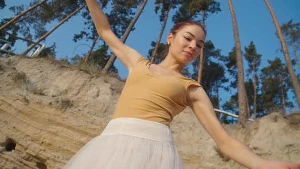 Bottom Angle View of Smiling Confident Beautiful Woman Dancing Ballet in Slow Motion at Background