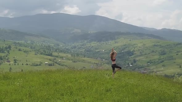 Young woman enjoying mountain view on a summer day. Relax and meditation in nature environment.