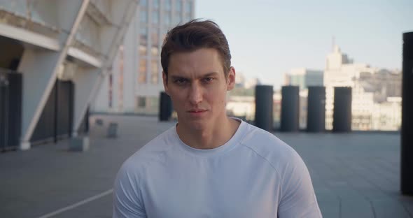 Portrait of a Confident Sporty Man Looking at the Camera in the Morning at the Stadium