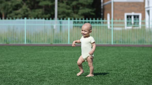 Baby Boy Walks on Green Grass Exploring Area on Sunny Day