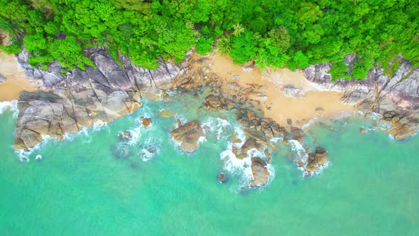 Aerial Top views over beaches, ocean waves crashing on rocks and sand