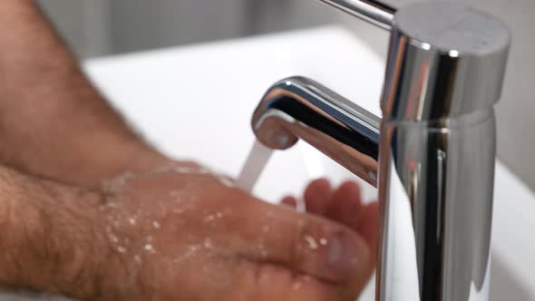 Male Hands Cleaning with Soap with a Tap