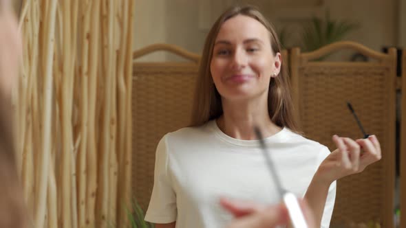 Woman Using Mascara on Eyelash in Bathroom in the Morning Time