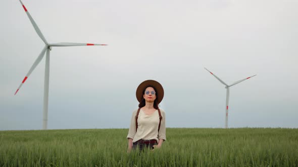 Portrait of a young girl looking ahead against the background of wind turbines