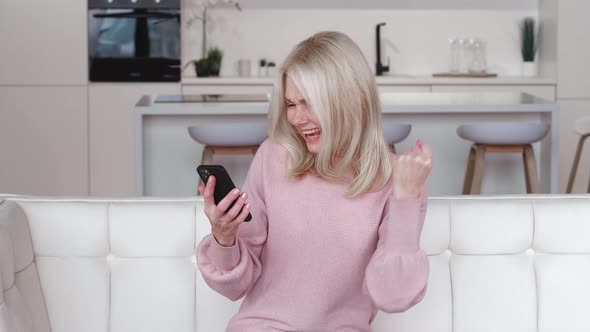 Excited Happy Mature Old 60s Woman Winner Holding Smartphone Using Mobile App Winning Online Lottery