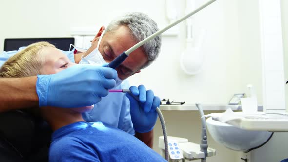 Dentist examining a young patient with tools