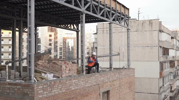 The foreman at the construction site controls the process using a walkie-talkie.