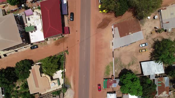 Rising flight towards Kololi road junction in Serrekunda Africa with traffic and people crossing and