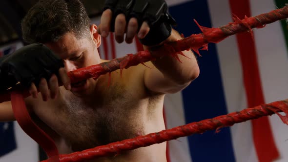 Tired male boxer standing in the ring