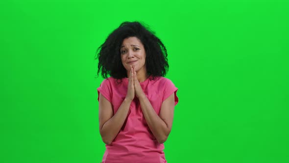 Portrait of Young Female African American Keeping Palm Together and Asking for Something