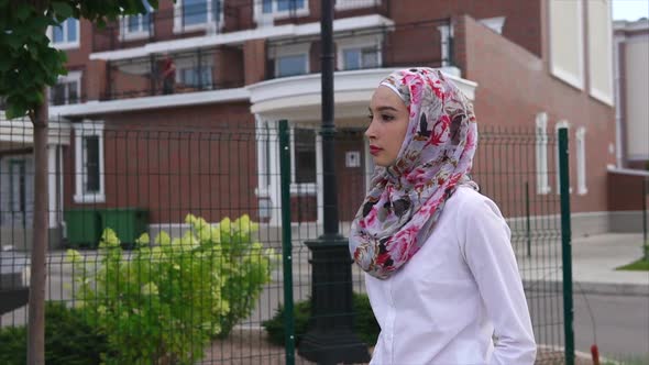 Young Arab Woman Walking Down the Street Wearing a Hijab in a Modern City