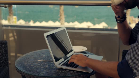 Freelancer Works Outdoors On Computer. Man Working On Laptop In Vocation.Freelance Male Using Laptop