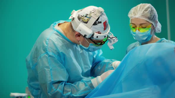 Team of surgeons doing plastic surgery in modern clinic