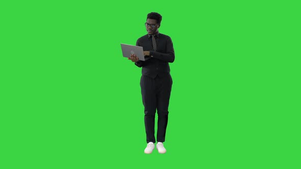 Confident African American Businessman Typing on Laptop on a Green Screen Chroma Key