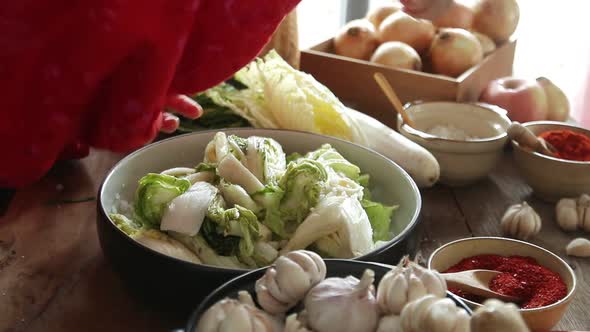 Korean women wear traditional hanboks, make kimchi.