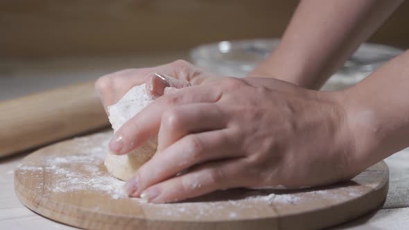 Italian Pizza Chef Forming the Dough on a Floured Surface and Kneading It with His Hands, in a