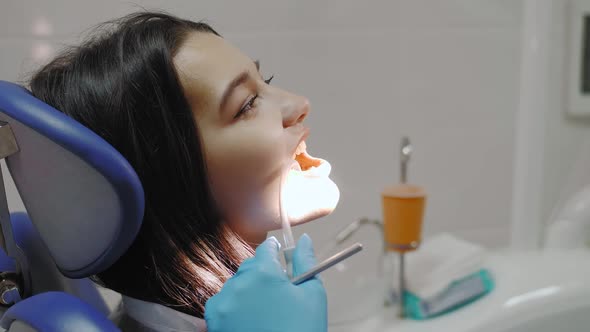 Dentist Examining a Patient's Teeth in the Dentist Office