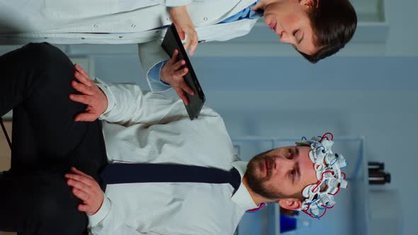 Vertical Video Man with Brainwave Scanning Headset Visiting Professional Doctor
