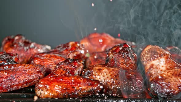 Super Slow Motion Shot of Seasoning Falling on Fresh Grilled Chicken Wings at 1000 Fps