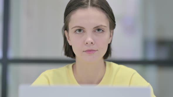 Close Up of Woman with Laptop Looking in Camera