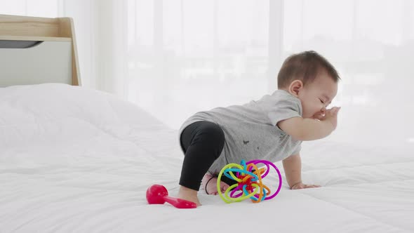 Young loving mother holding her baby on bed at home