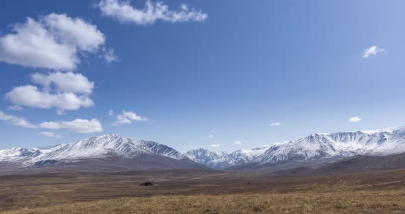 Timelapse of Sun Movement on Crystal Clear Sky with Clouds Over Snow Mountain Top