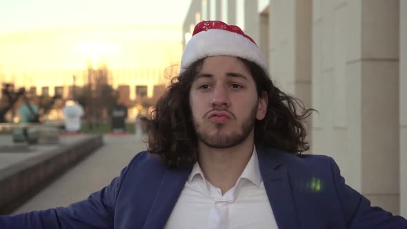 Happy Man Dancing in Santa Claus Hat Outdoors