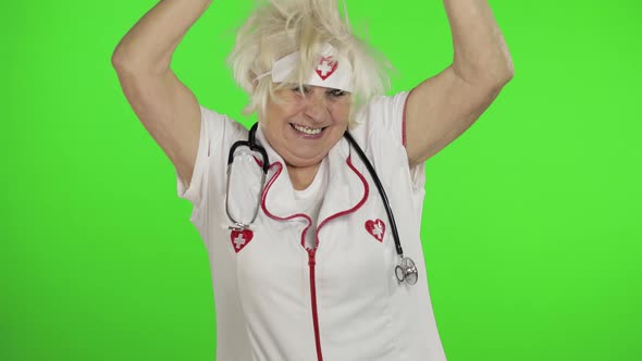 Portrait of Elderly Caucasian Female Doctor Dance. Crazy and Funny Nurse