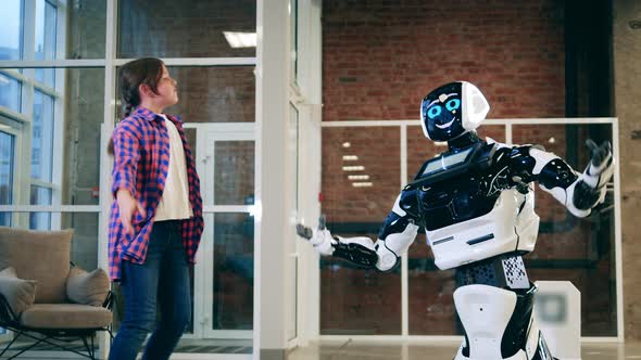 A Girl is Jumping and Dancing Near a Cyborg